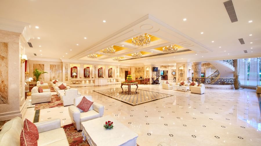 Elegant lounge area at Accord Hotels and Resorts featuring cushioned seating, tables, soft lighting, and sleek, reflective tiles.
